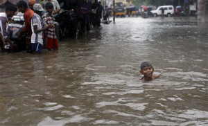 An Indian child swims through a waterlogged subway during heavy rains in Chennai, India, Monday, Nov. 9, 2015. Heavy rains continue to lash several parts of the city after the India Meteorological Department alerted a cyclone warning on the Bay of Bengal coast likely to make landfall between Chennai and Puducherry on Monday evening, according to local reports. (AP Photo/Arun Sankar K.)
